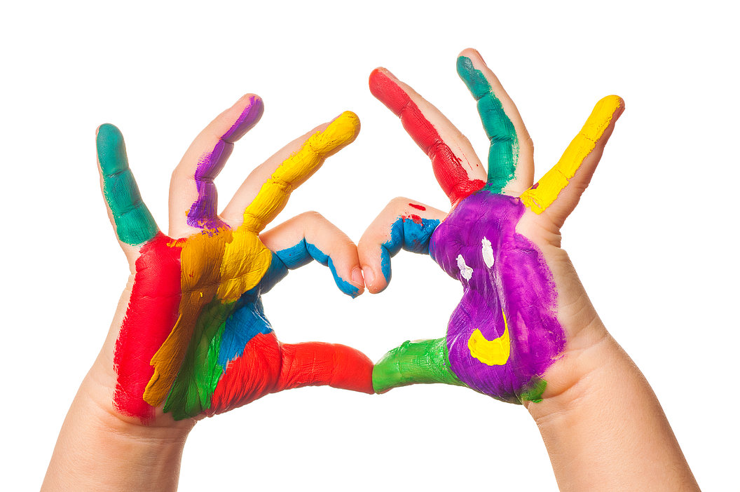 Zwei Hände mit bunten Fingerfarben, die zusammen ein Herz formen.